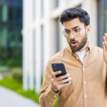 Pavilion - Understand Emotional Triggers - Edited. A man standing on a sidewalk yells at his phone with a frustrated voice